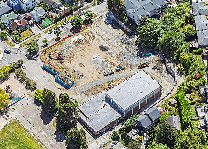 aerial photo of a building with a construction area in front of it including equipment and piles of gravel